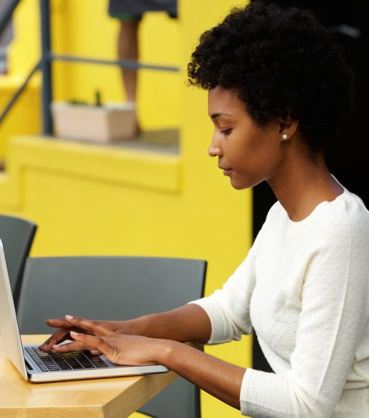 attractive-young-woman-using-laptop-outside-P9RLFGU-721x817
